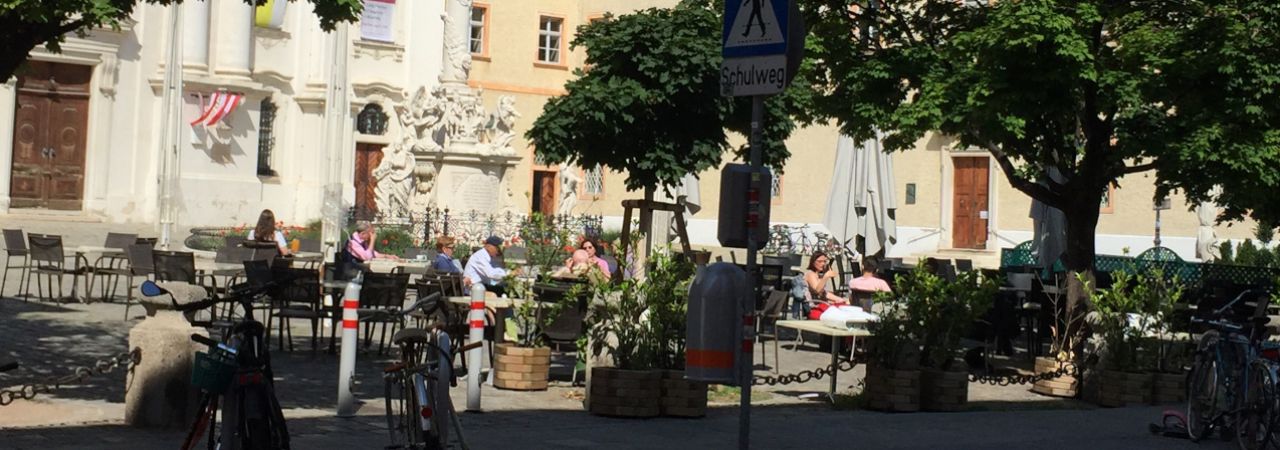 Platz in Wien mit Grünfläche und Sitzgelegenheiten