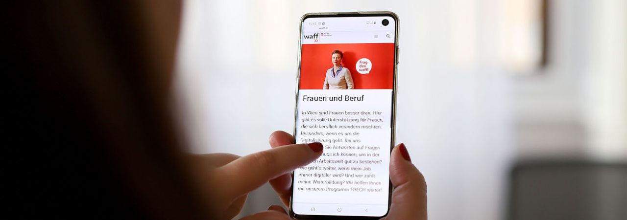 Eine Frau informiert sich am Smartphone zum Frauen-Berufsprogrammen des waff