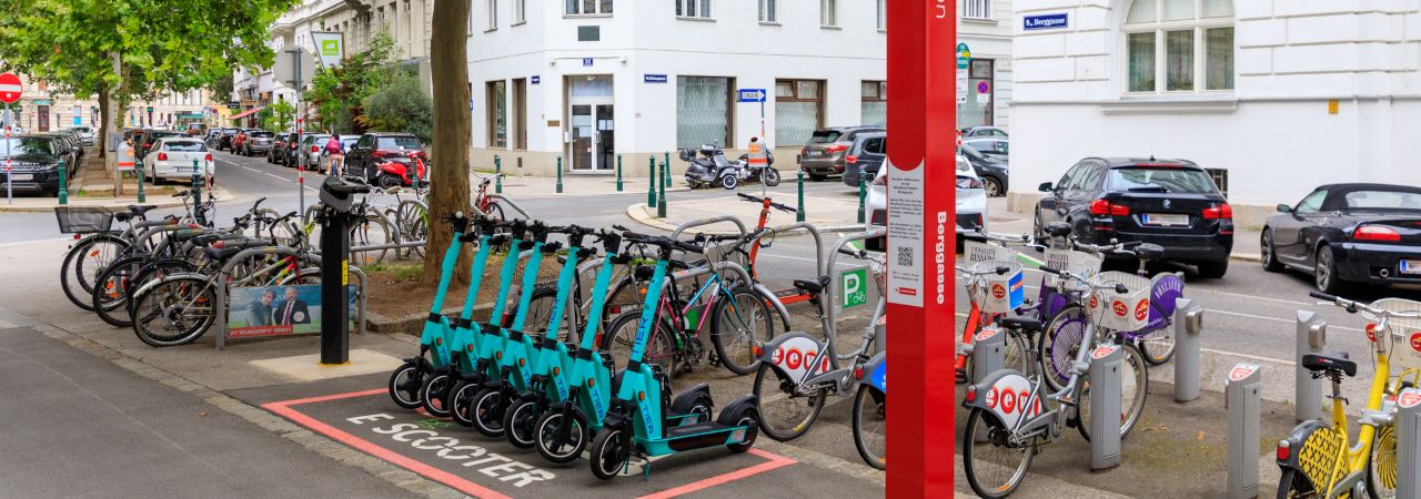 WienMobil Station der Wiener  Linien, im Vordergrund E-Scooter, im Hintergrund Leihräder
