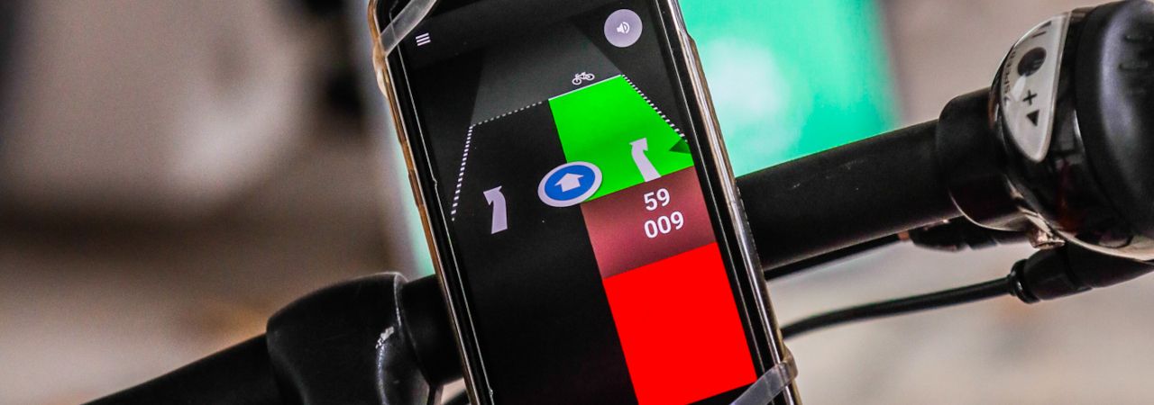 Smartphone auf Fahrradlenker mit geöffneter Grüner-Welle-App