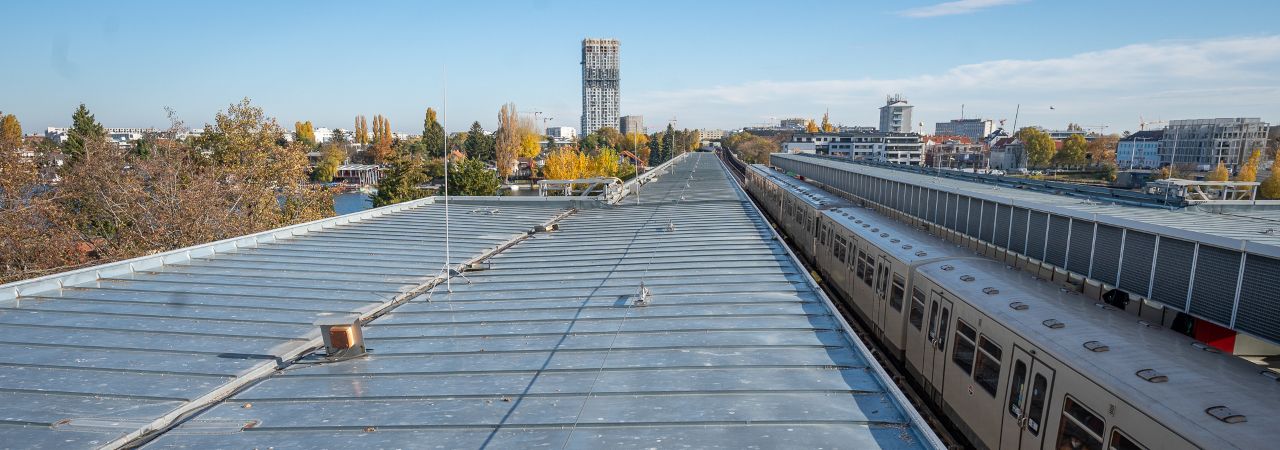 Dach einer U-Bahnstation an einem Herbsttag. In der Station steht eine U-Bahn.