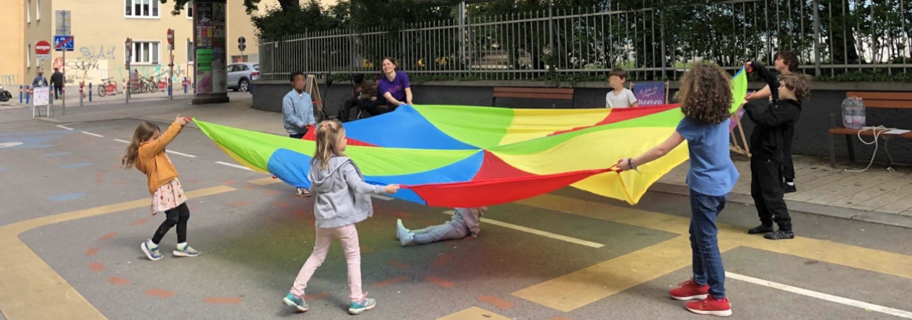 Kinder spielen mit einem bunten Schwungtuch