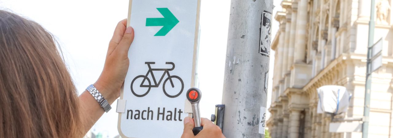 Verkehrsschild mit Fahrradsymbol und grünem Pfeil nach rechts