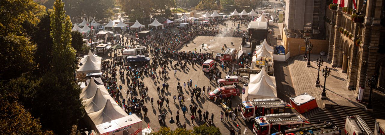 Einsatzfahrzeuge und Besucher*innen beim Sicherheitsfest auf dem Rathausplatz