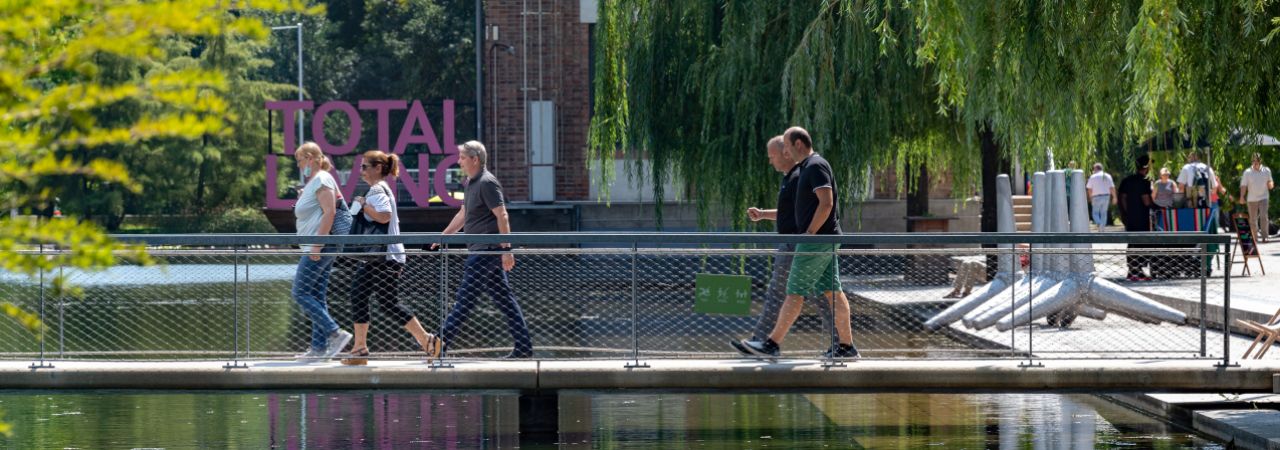 Menschen gehen über eine Fußgängerbrücke.