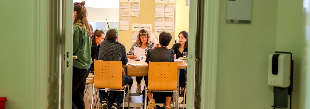 Mehrere Menschen in einem Raum bei der Projektplanung