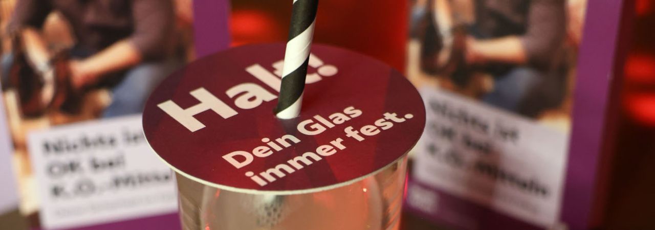 Glasabdeckung  der Kampagne 'Nichts ist O.K. bei K.O.-Tropfen' auf einem Glas