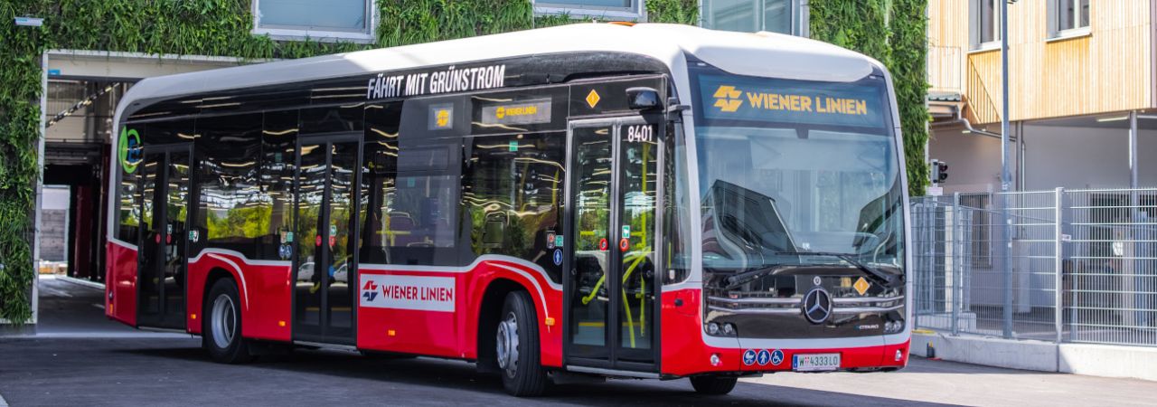 Begrünte Fassade des Kompetenzzentrums, davor ein E-Bus der Wiener Linien
