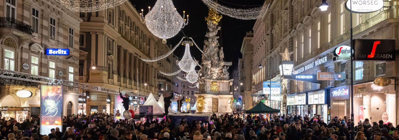 Menschen tanzen bei Nacht am Graben Walzer