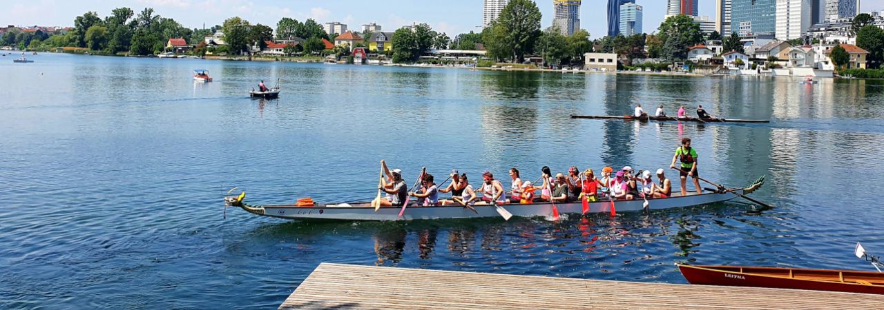 Kinder rudern gemeinsam in einem Ruderboot auf der Alten Donau