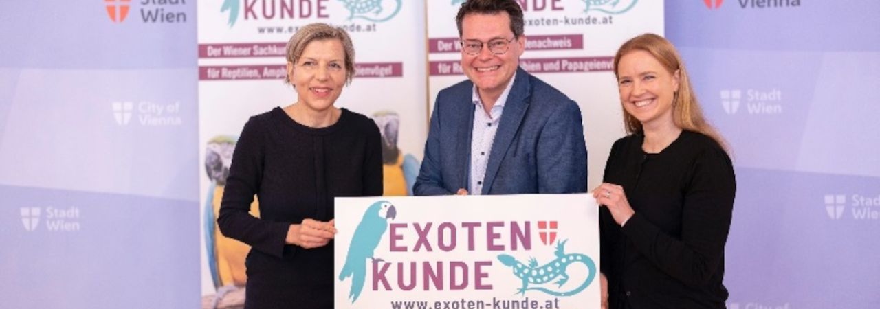 Két nő és egy férfi egy táblát tart a kezében