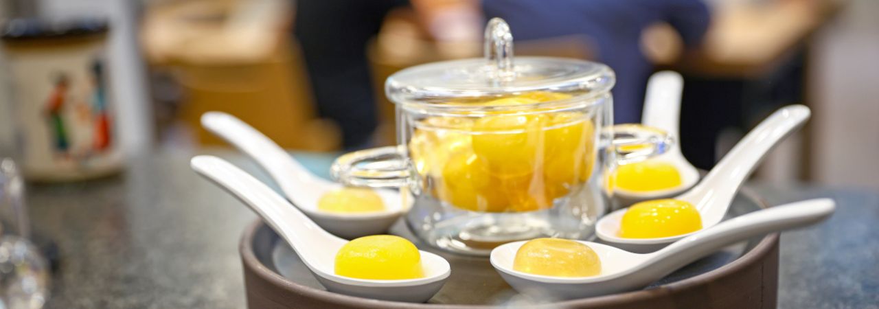 Flüssigkeitstropfen auf asiatischen Suppenlöffeln angerichtet.