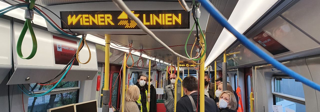 Fahrt mit einem U-Bahn-Waggon mit Leuchtschrift und Personen mit Mund-Nasen-Schutz