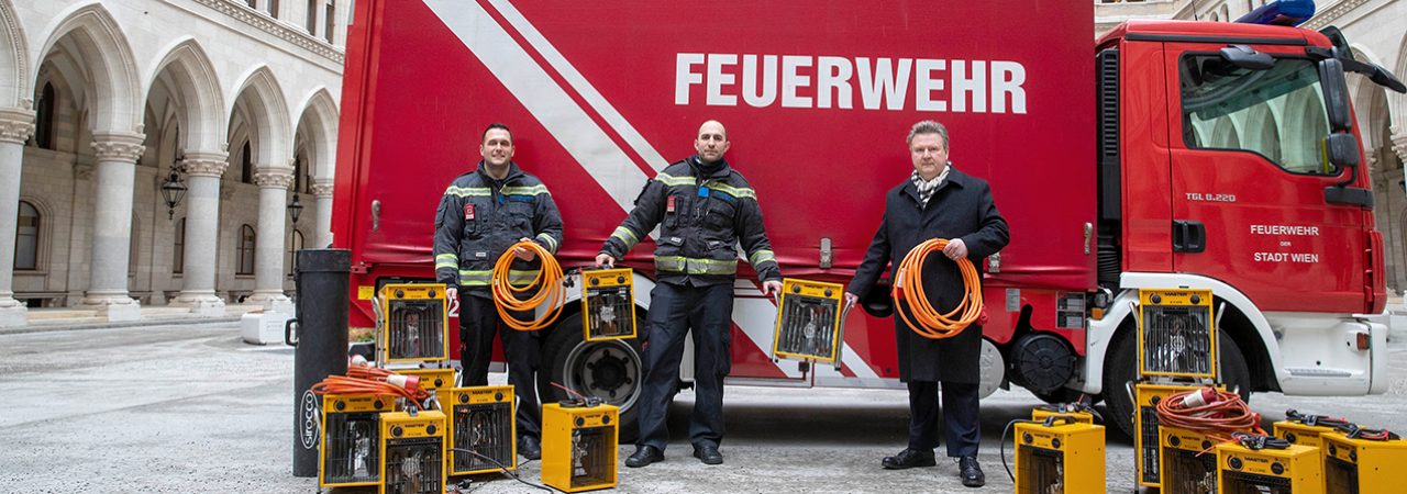 Bürgermeister Michael Ludwig (rechts) mit Feuerwehrleuten vor Transporter
