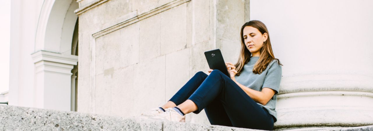 Junge Frau mit Tablet auf Steinstiege