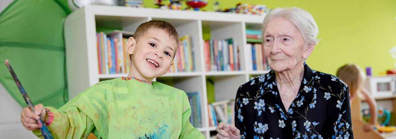 Seniorin mit Buben beim Malen in einem Kolpinghaus 'Gemeinsam leben'
