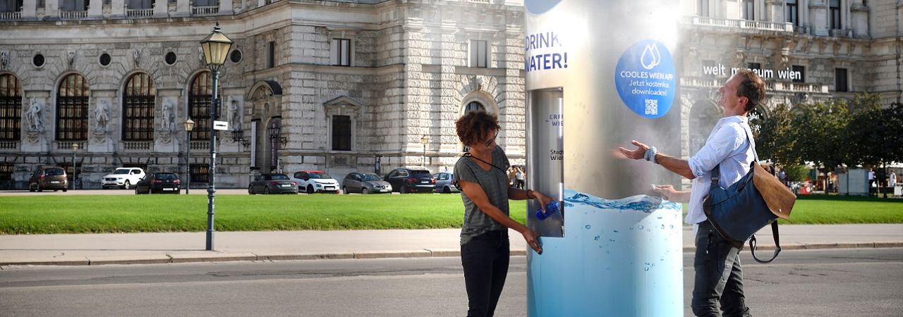 žena i muškarac se rashlađuju na mobilnoj česmi s pitkom vodom