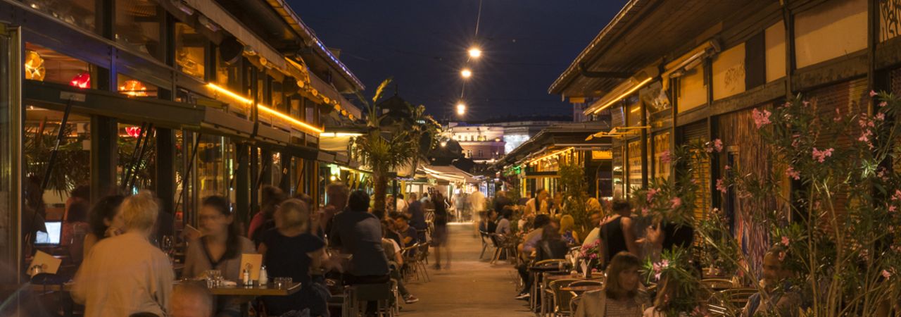 puno ljudi sjedi na tržnici noću
