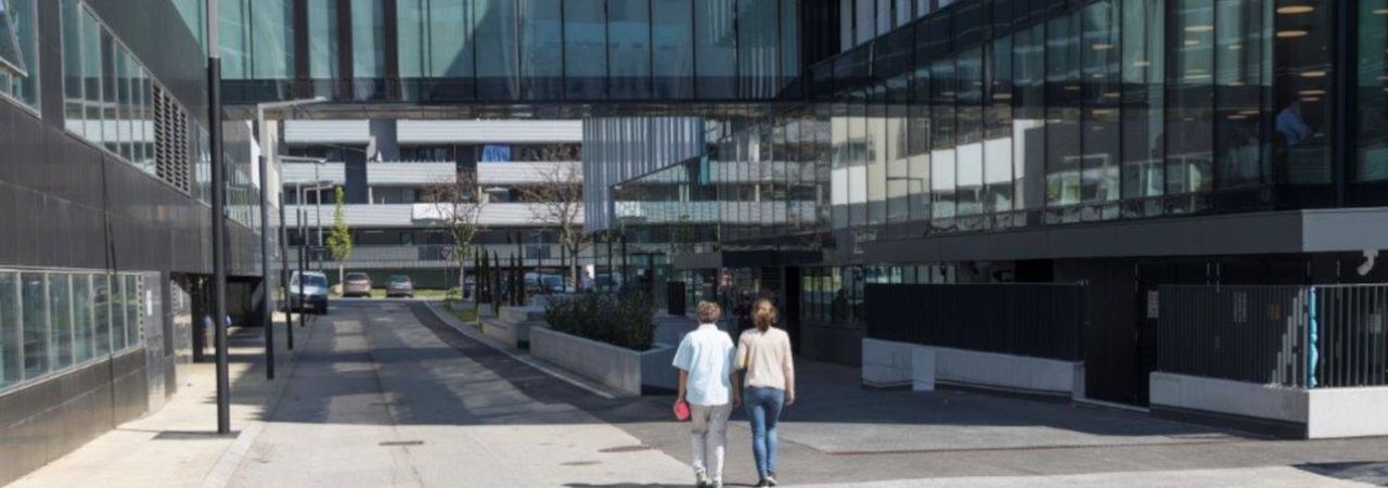 Zwei Personen gehen an Bürogebäude in Neu Marx vorbei