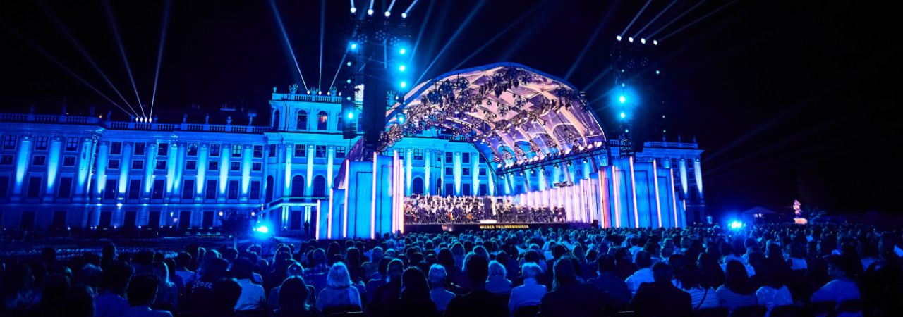 Bečka filharmonija na pozornici ispred publike u vrtu dvorca Schönbrunn noću