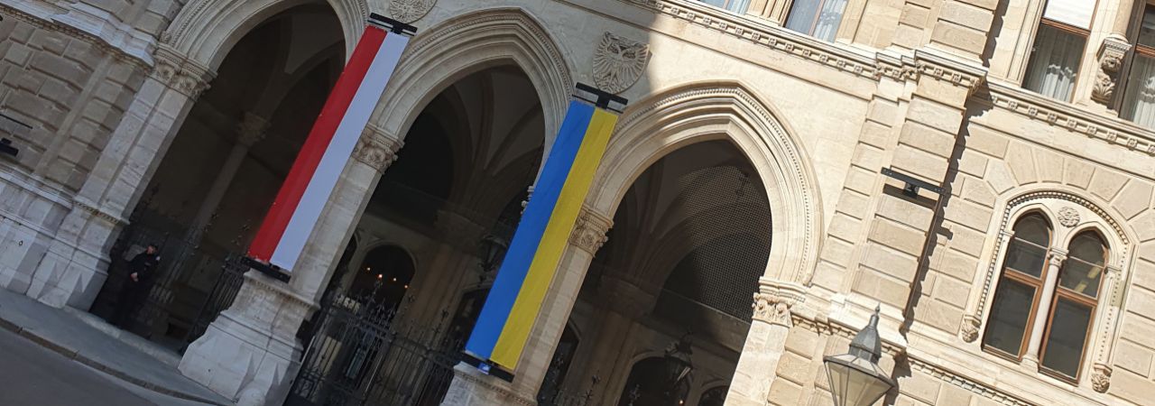 Seiteneingang des Wiener Rathauses, an den Seiten beflaggt mit der Wiener und der ukrainischen Fahne