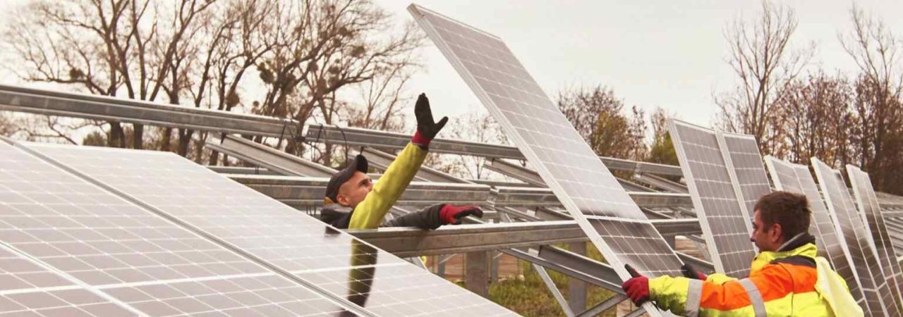 Работници монтират соларни панели на покрив