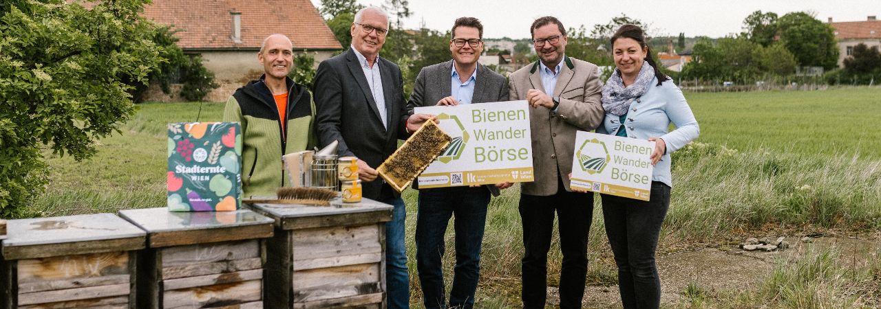 Заместник-кметът и група хора представят борсата за пчели пред пчелни кошери