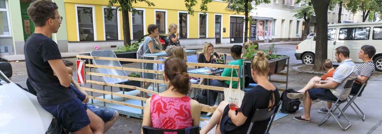 Eine Gruppen von Menschen unterhält sich bei einer Veranstaltung im öffentlichen Raum - Grätzloase