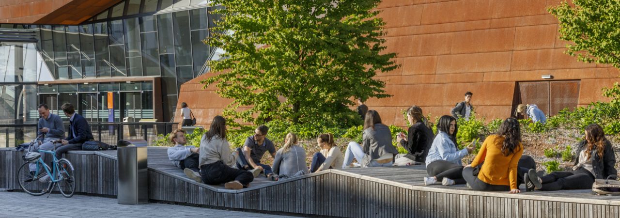 Gruppe von jungen Menschen vor einem WU-Gebäude sitzend