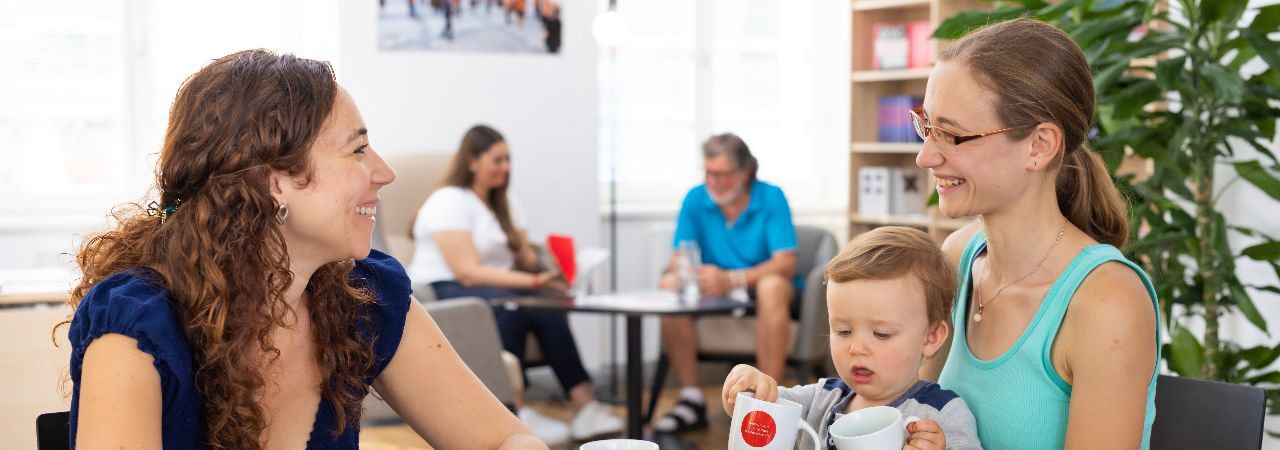 Zwei Frauen und ein Kind an einem Tisch