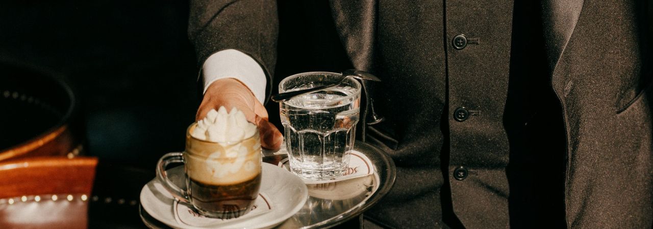 Ein Mann trägt einen Kaffee