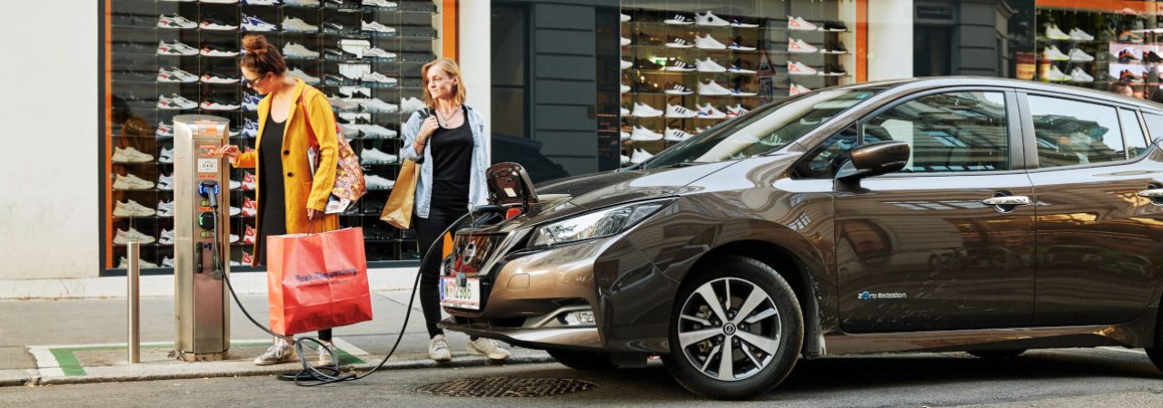 Zwei Frauen laden Auto an E-Tankstelle